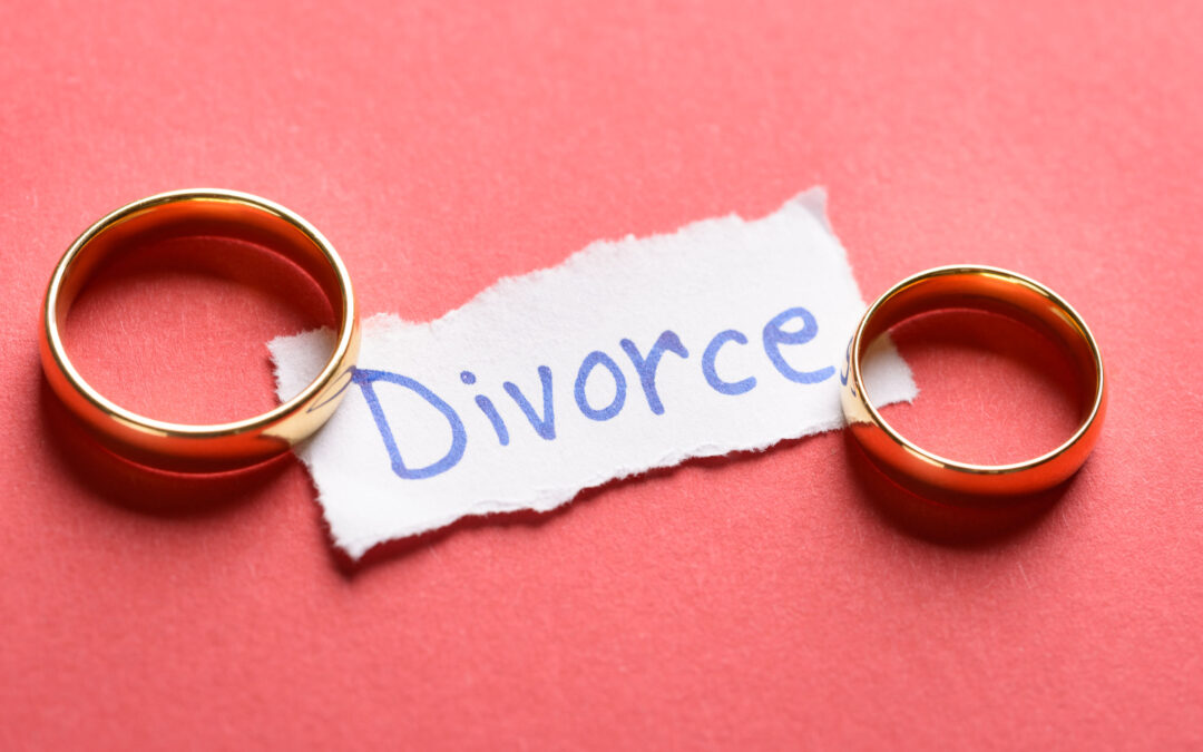 An image of wedding rings at both ends of a piece of paper that reads "divorce"